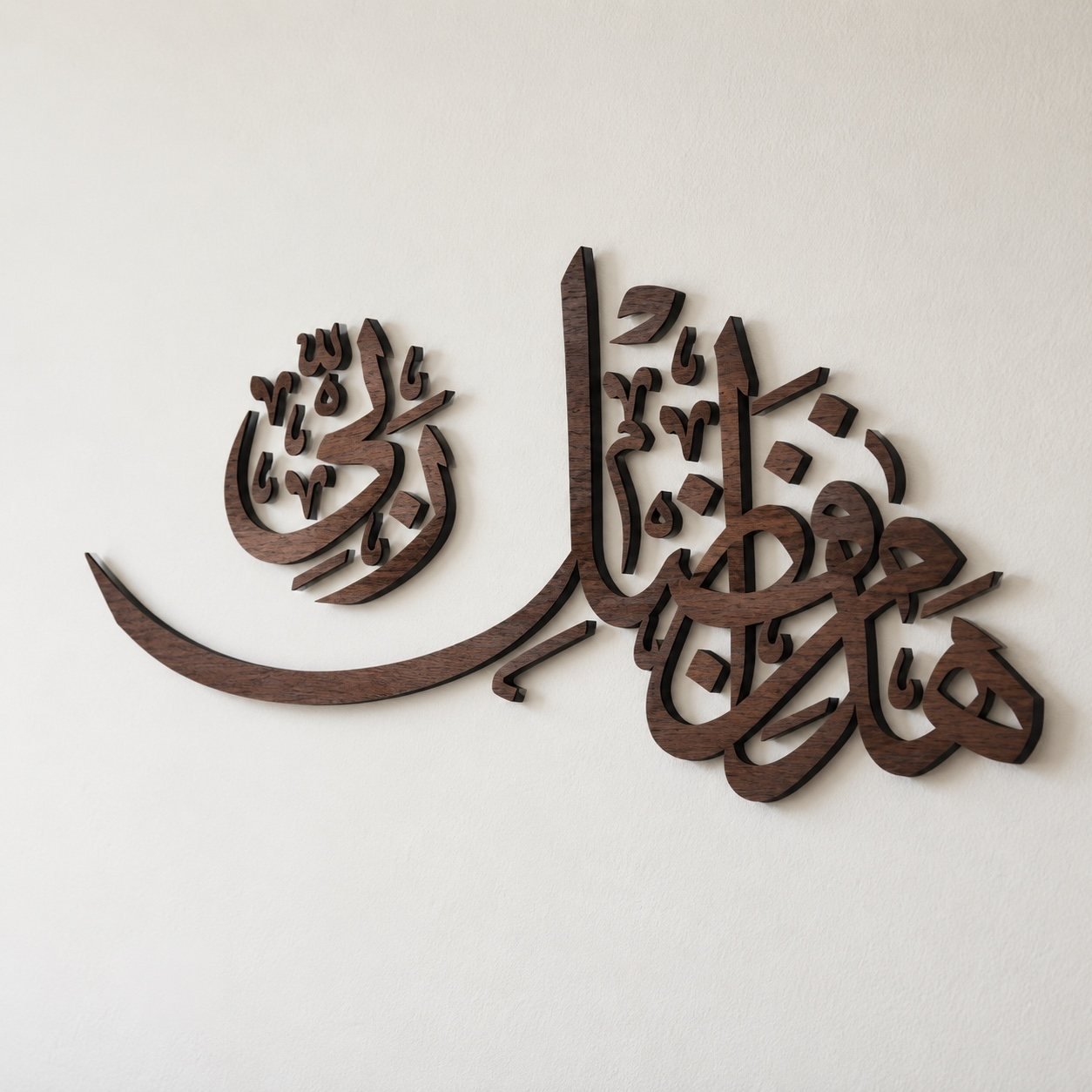 Angled view of Hadha min Fadli Rabbi Arabic calligraphy wall art showing dimensional wood and aluminum edges with wall shadow.