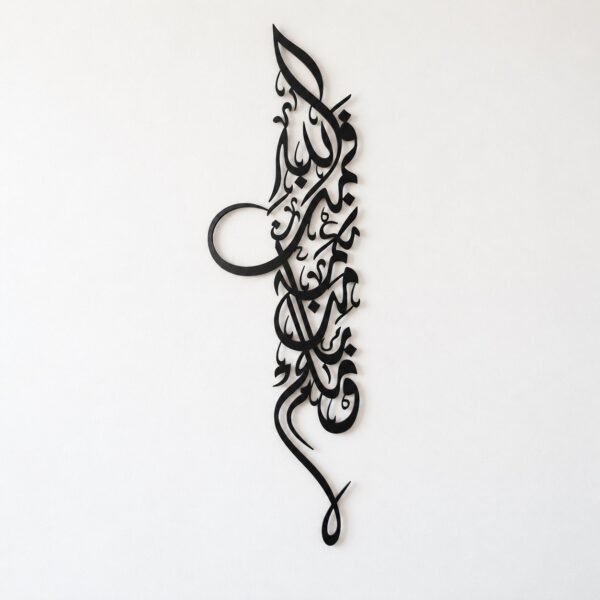Front view of black metal Arabic calligraphy wall art on a plain warm-white wall.