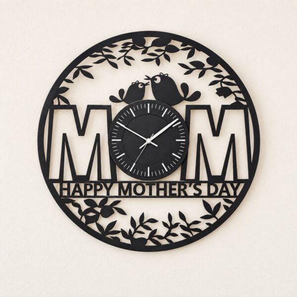 Black round Mothers Day metal wall clock on a plain warm-white wall, front view.